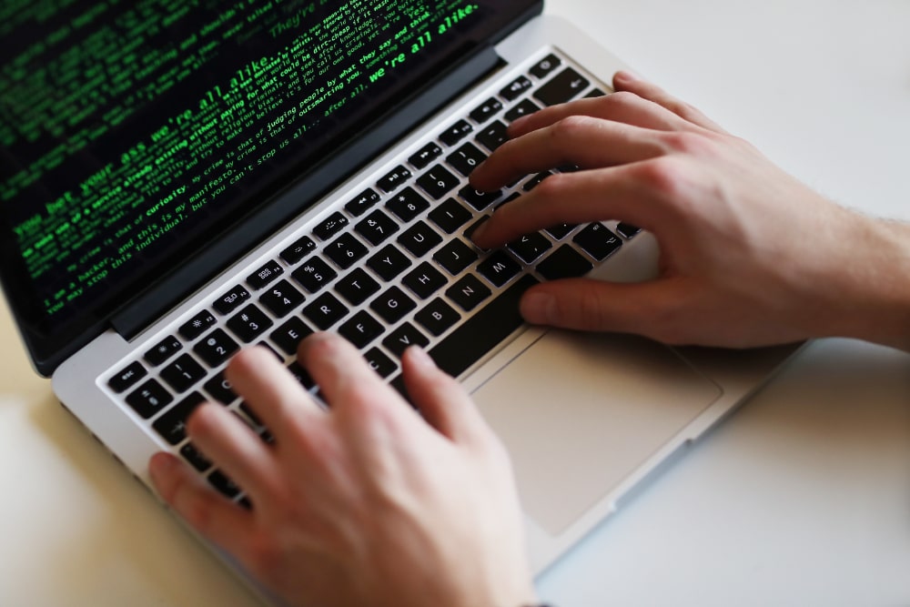 man op laptop hackt domotica