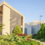 Grijs gebouw van de Frederick University op Cyprus. Voor de ingang met vier glazen deuren een brede trap bestaande uit 13 treden. Deel van het EU project INBLANC duurzaam wonen en werken waaraan Comfortica deelneemt.