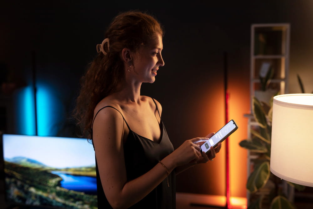mevrouw bedient slimme verlichting met kleur